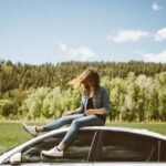 bild på en tjej som sitter på taket på en bil