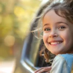 Litet barn som leker billekar och glatt tittar ut genom fönstret på bilen